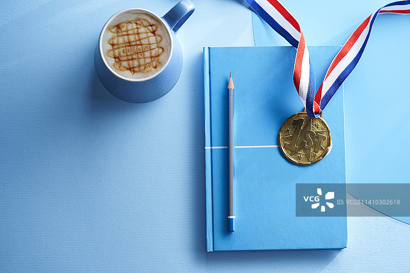 蓝色空白记事本、金牌和咖啡杯，马来西亚图片素材