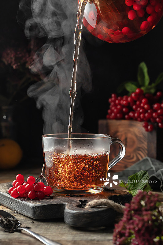 倒入杯中的荚蒾茶，秋季倾倒过程图片素材