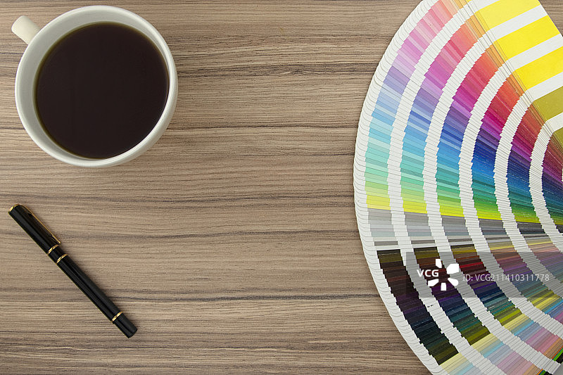 英国木桌上的色卡、咖啡和笔图片素材