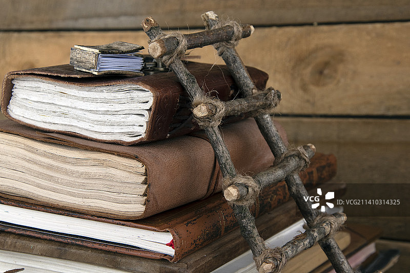 一堆老木制书本与微型木梯和微型木书，英国图片素材