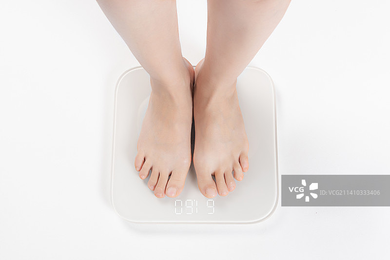 女性电子秤上称体重图片素材