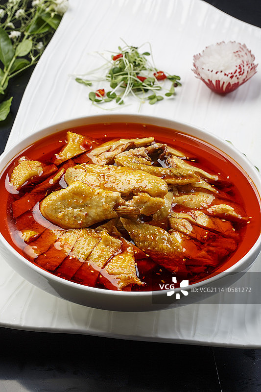 扇形瓷盘摆放的白瓷碗装的麻辣口水鸡图片素材