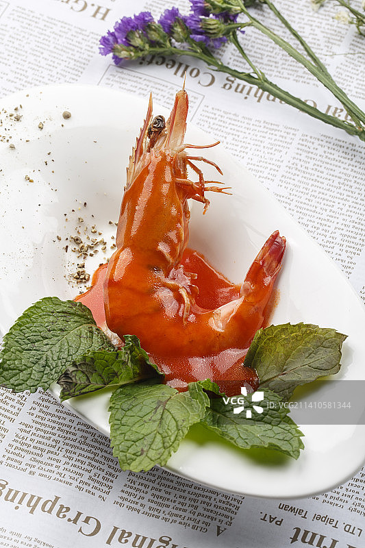 白色椭圆瓷盘装的浇汁大明虾图片素材