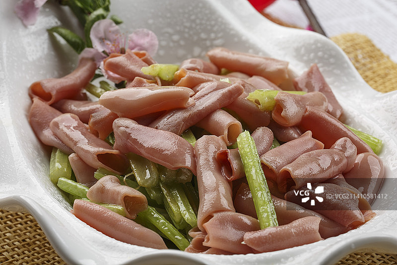 浪花边白色瓷盘装的海鲜清香海肠图片素材