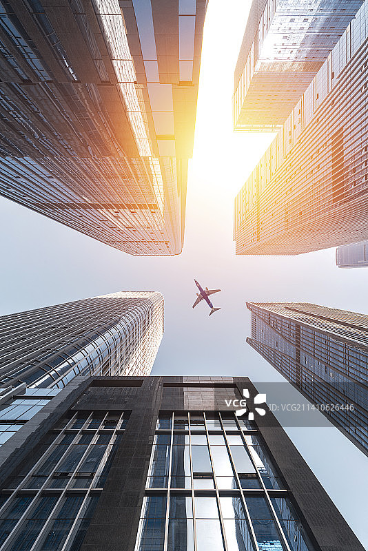 飞机穿过城市摩天大楼图片素材
