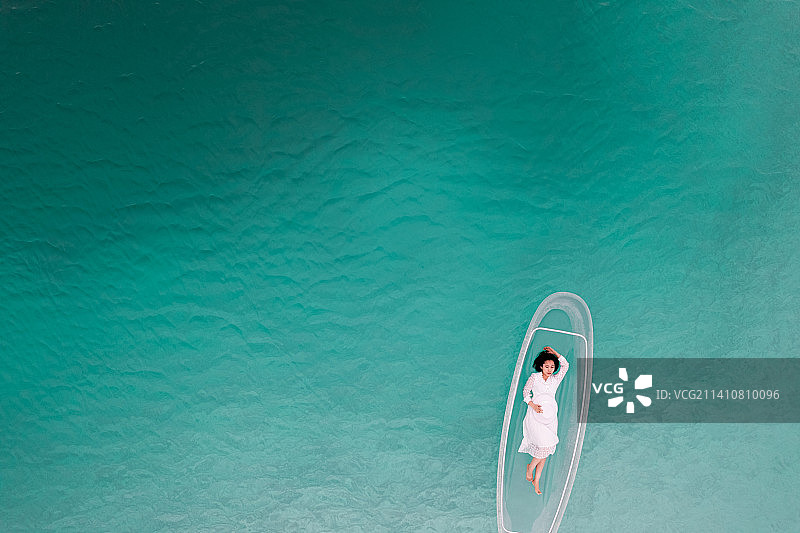 在中国青海大柴旦翡翠湖,在透明“玻璃船”上的的女性游客 航拍视角图片素材