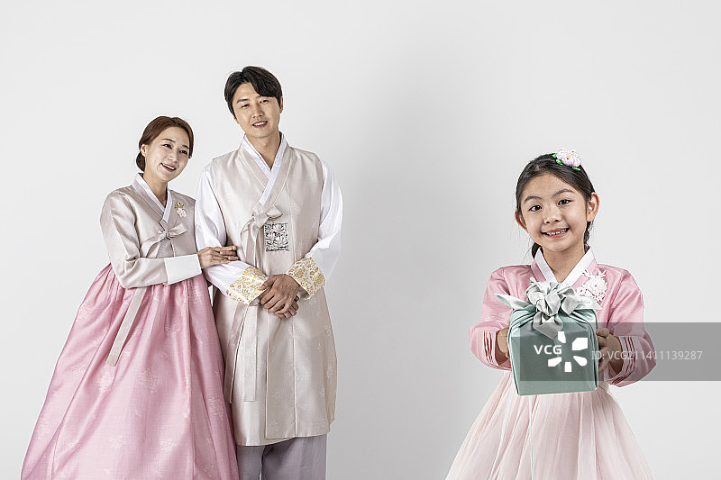 穿着韩服的韩国家庭，拿着礼物，白色背景图片素材