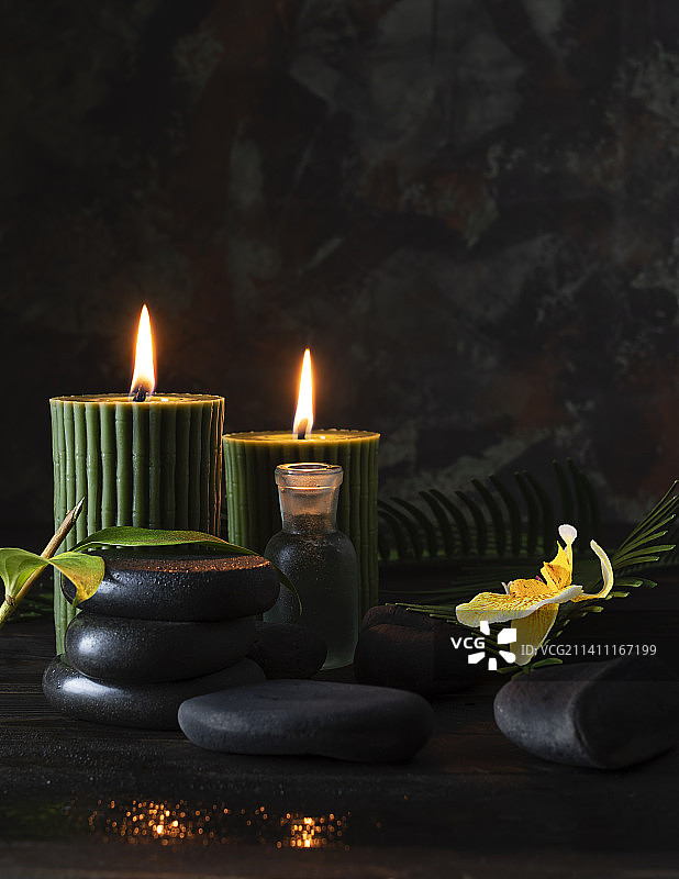 深色木桌上带有竹子图案的绿色蜡烛图片素材