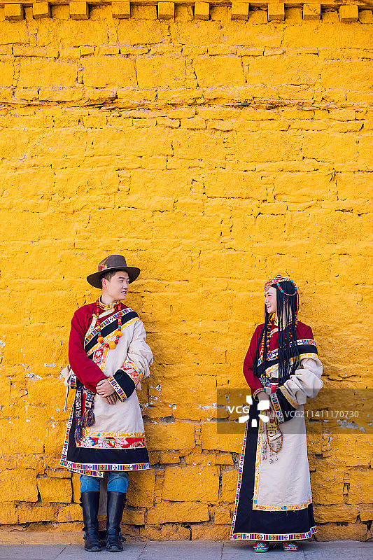 中国拉萨布达拉宫黄墙前的少数民族藏族夫妇，国潮模特扮演图片素材