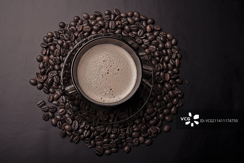 黑色背景上带咖啡豆的咖啡杯俯视照片图片素材