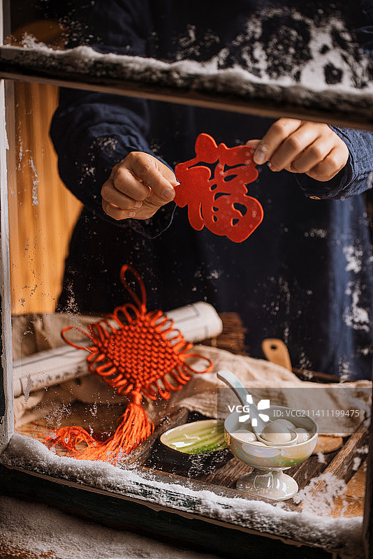 雪后的窗边桌上摆着汤圆元宵手拿福字图片素材