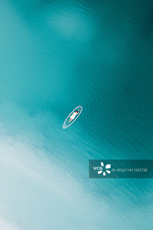 在中国青海大柴旦翡翠湖,在透明“玻璃船”上的的女性游客 航拍视角图片素材