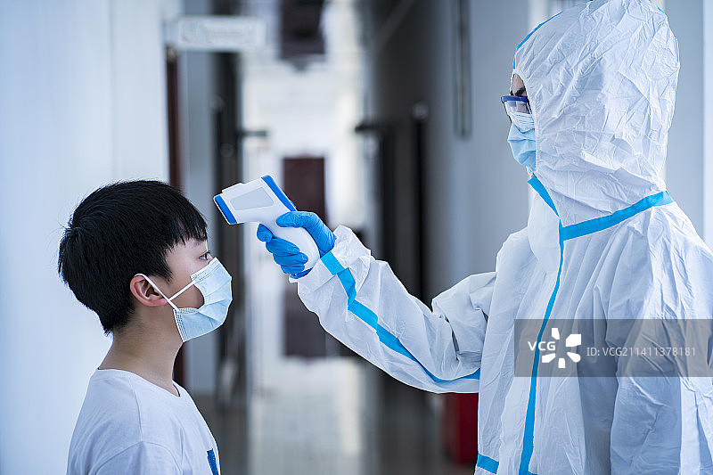 正接受额温枪测体温的小男孩图片素材