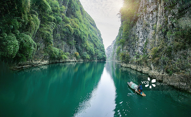 深山山谷河流小渔船在碧绿如明镜水面中静静划过碧波荡漾一叶小舟撒开渔网峡谷环境清幽安详充满意境之美图片素材