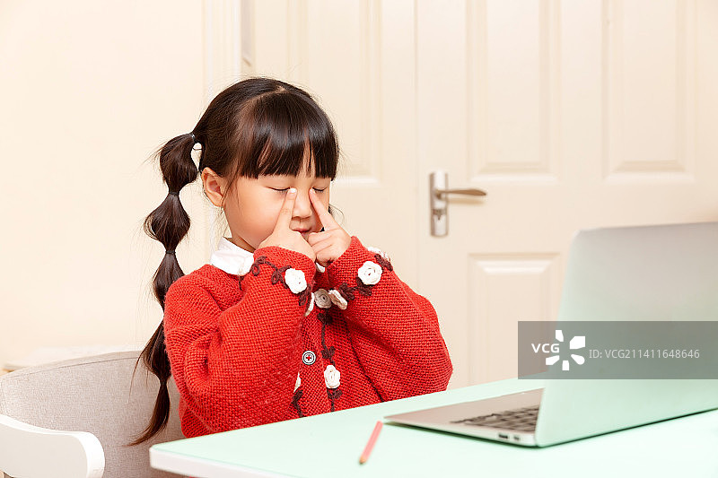 居家对着电脑上网课的小学女生课间做眼保健操图片素材