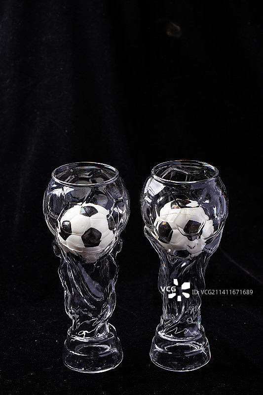 黑色背景大力神杯啤酒杯和黑白足球图片素材