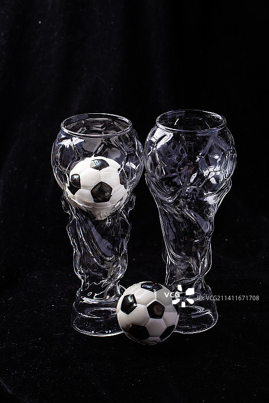 黑色背景大力神杯啤酒杯和黑白足球图片素材