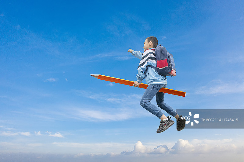 骑在铅笔上的小学生图片素材