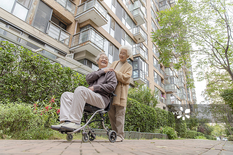 推着轮椅遛弯的老年夫妇图片素材