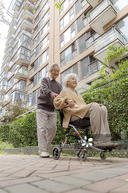 推着轮椅遛弯的老年夫妇图片素材