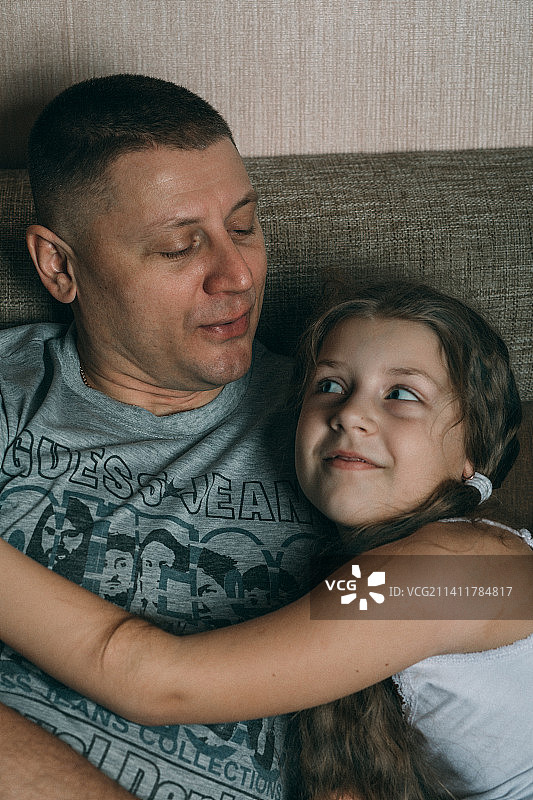 在家和可爱小女儿在一起的英俊年轻人，非常开心图片素材