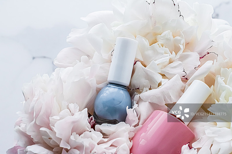 花卉背景上的指甲油瓶，法式美甲和化妆品图片素材