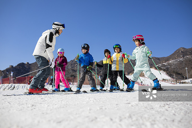 孩子们跟着教练在户外学滑雪图片素材