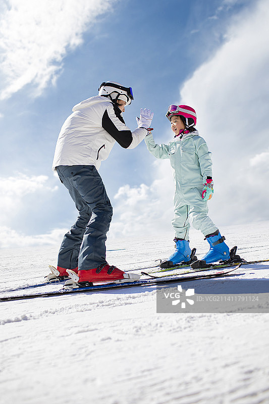 小女孩跟着教练在户外学滑雪图片素材