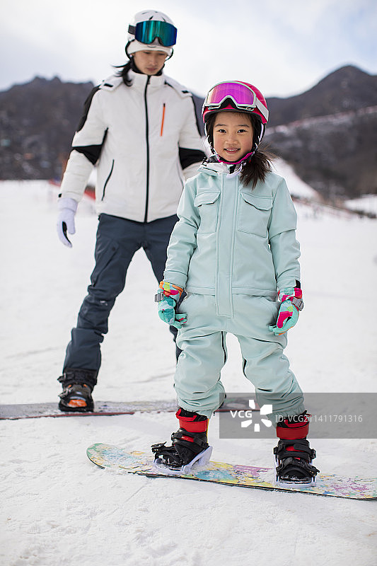 小女孩跟着教练在户外学滑雪图片素材