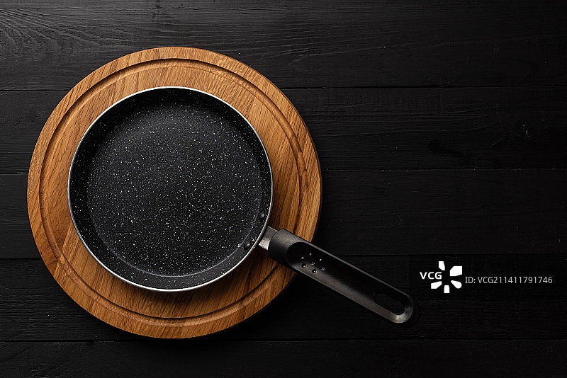 木板上的空锅：大理石涂层铁锅图片素材