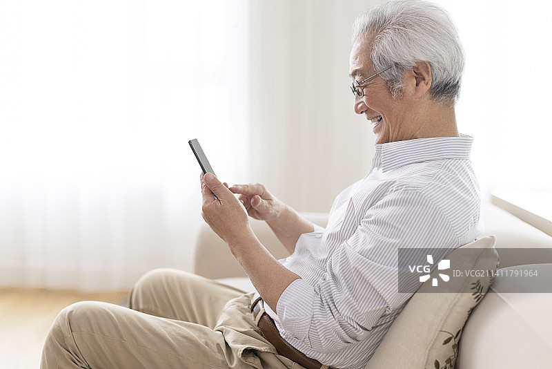 老年男子在家使用手机图片素材