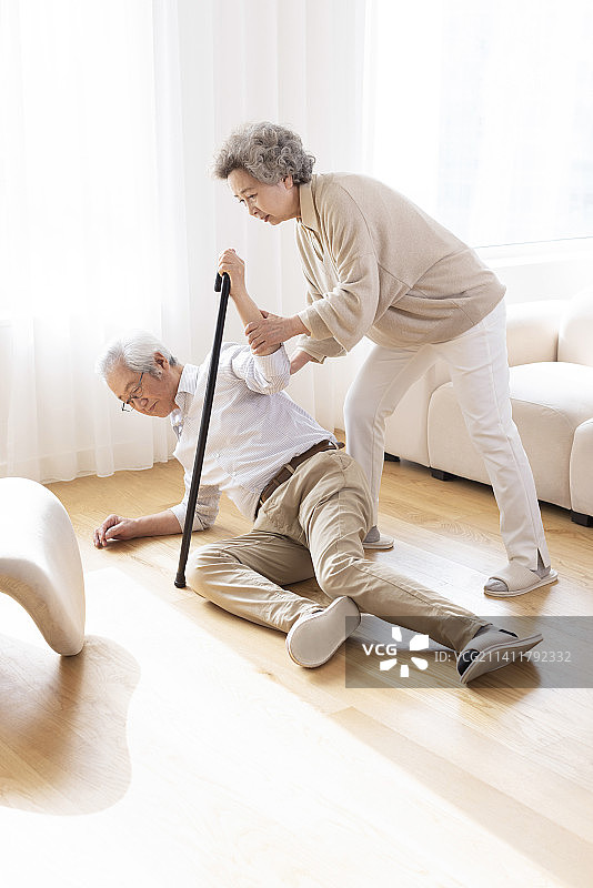 妻子搀扶摔倒的丈夫起来图片素材