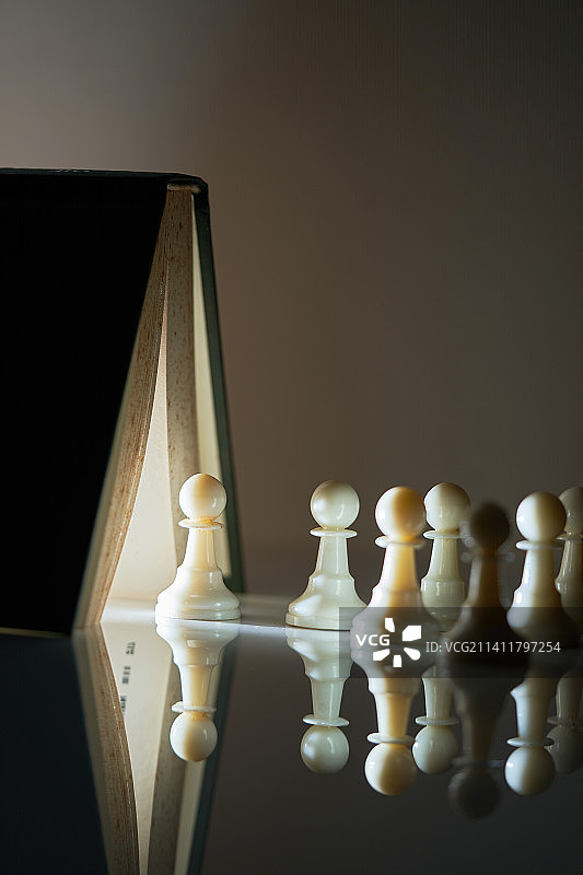 书本光束照亮一排棋子，马来西亚图片素材