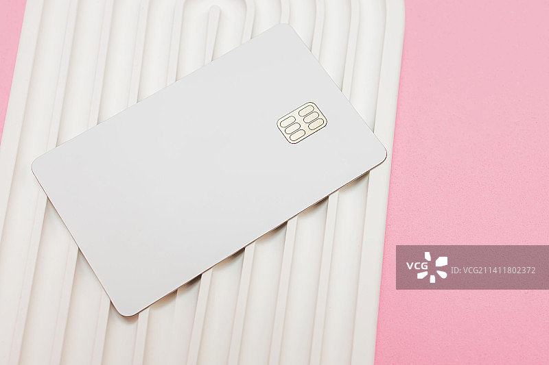 波浪形白色石面上的白色信用卡或借记卡，带芯片图片素材