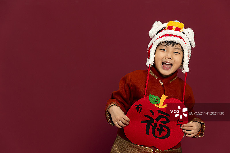 儿童庆祝春节系列：欢乐的小男孩拿着福字庆祝新春图片素材