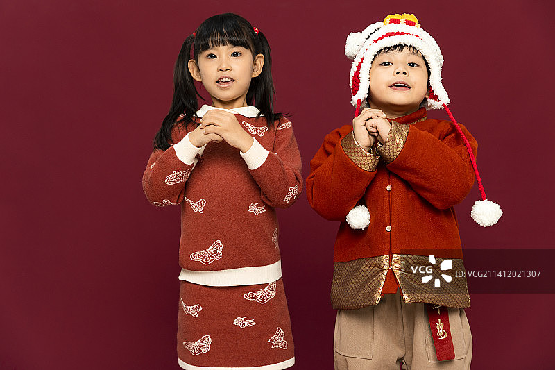 儿童庆祝春节系列：欢乐的男孩女孩拜年图片素材