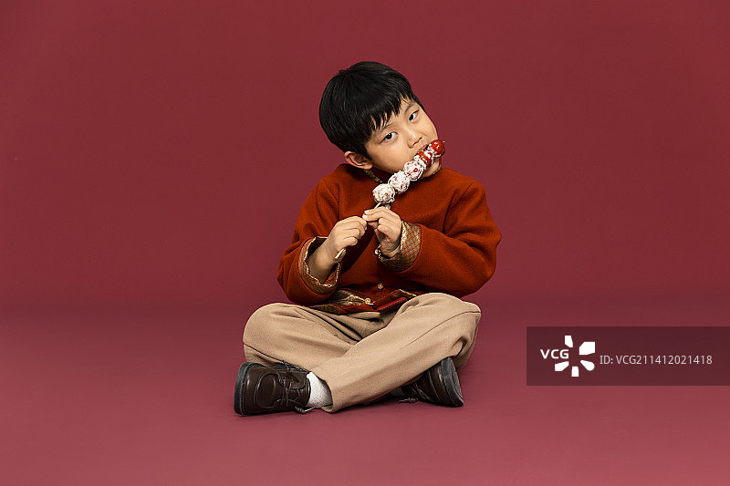儿童庆祝春节系列：小男孩吃糖葫芦庆祝新春图片素材