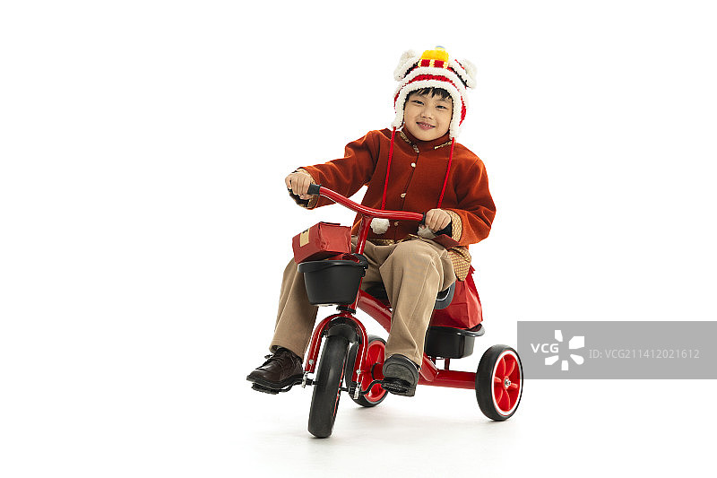 儿童庆祝春节系列：小男孩骑着小三轮车运送春节礼物图片素材