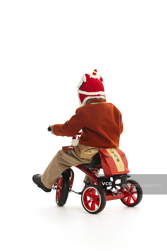 儿童庆祝春节系列：小男孩骑着小三轮车运送春节礼物图片素材