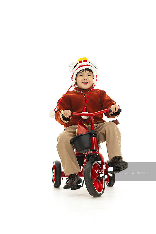 儿童庆祝春节系列：小男孩骑着小三轮车运送春节礼物图片素材