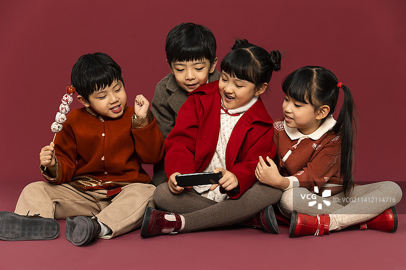 儿童庆祝春节系列：欢乐的儿童们用手机抢过年红包嬉戏玩耍图片素材