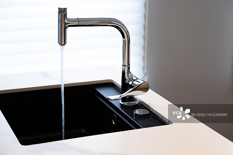 出水中的金属水龙头图片素材