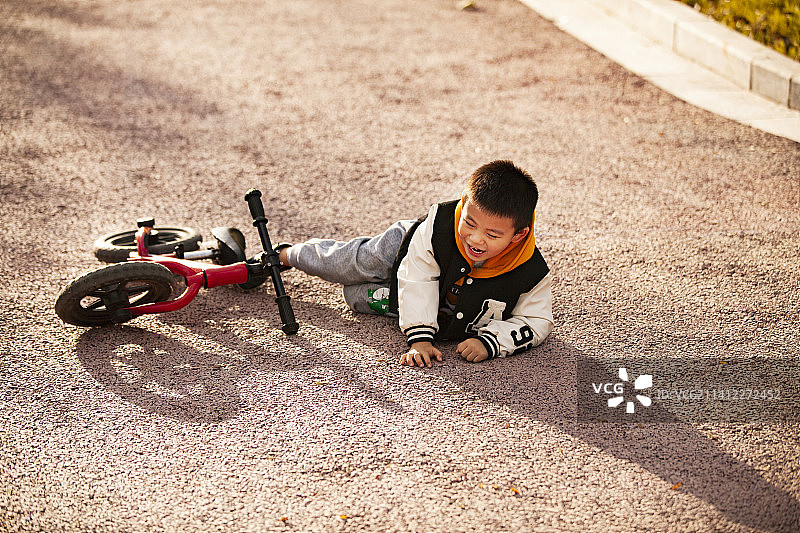 小男孩骑自行车摔倒了图片素材