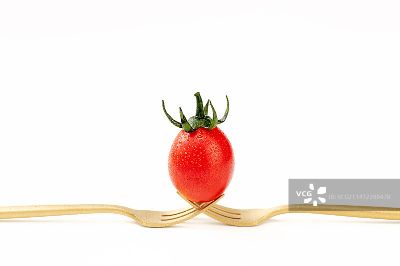 白色背景中的铜叉子和小番茄组合图图片素材