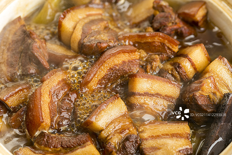 正在砂锅中烹调的红烧肉特写图片素材