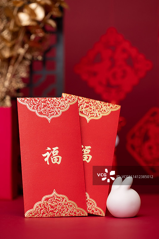 桌子上的红包与兔子,红色背景,新年气氛图片素材