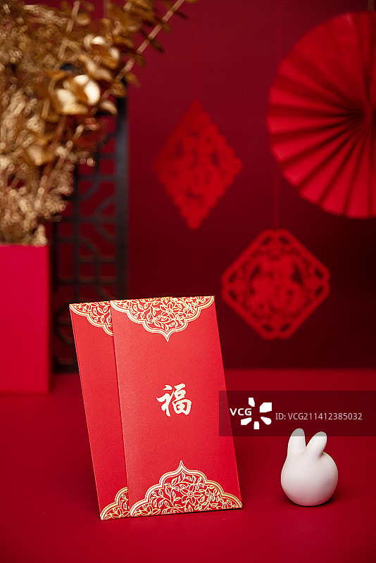 桌子上的红包与兔子,红色背景,新年气氛图片素材