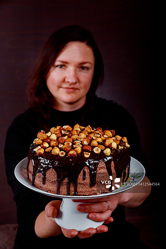 快乐的糕点厨师展示她的自制蛋糕图片素材