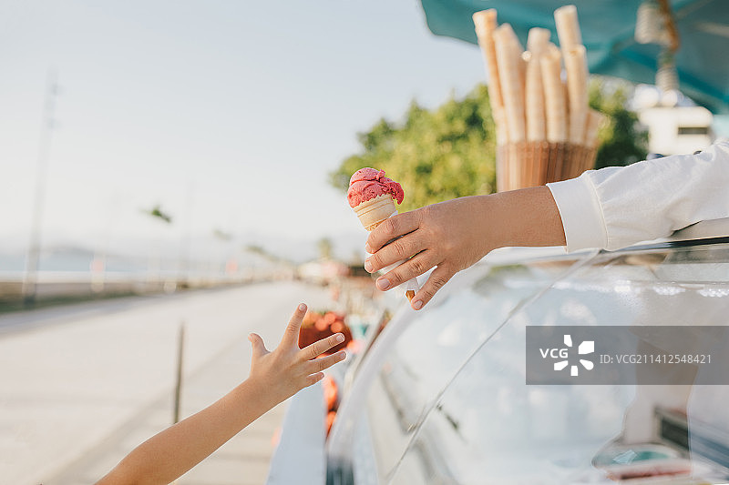 可爱的小女孩站在冰淇淋店附近购买冰淇淋甜筒，土耳其图片素材