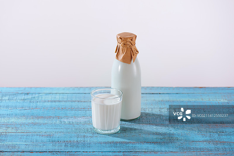 白色背景下桌子上的牛奶瓶特写图片素材